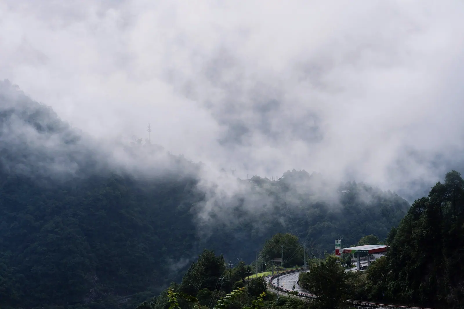 浓雾从山腰漫上来,一条公路盘进云里