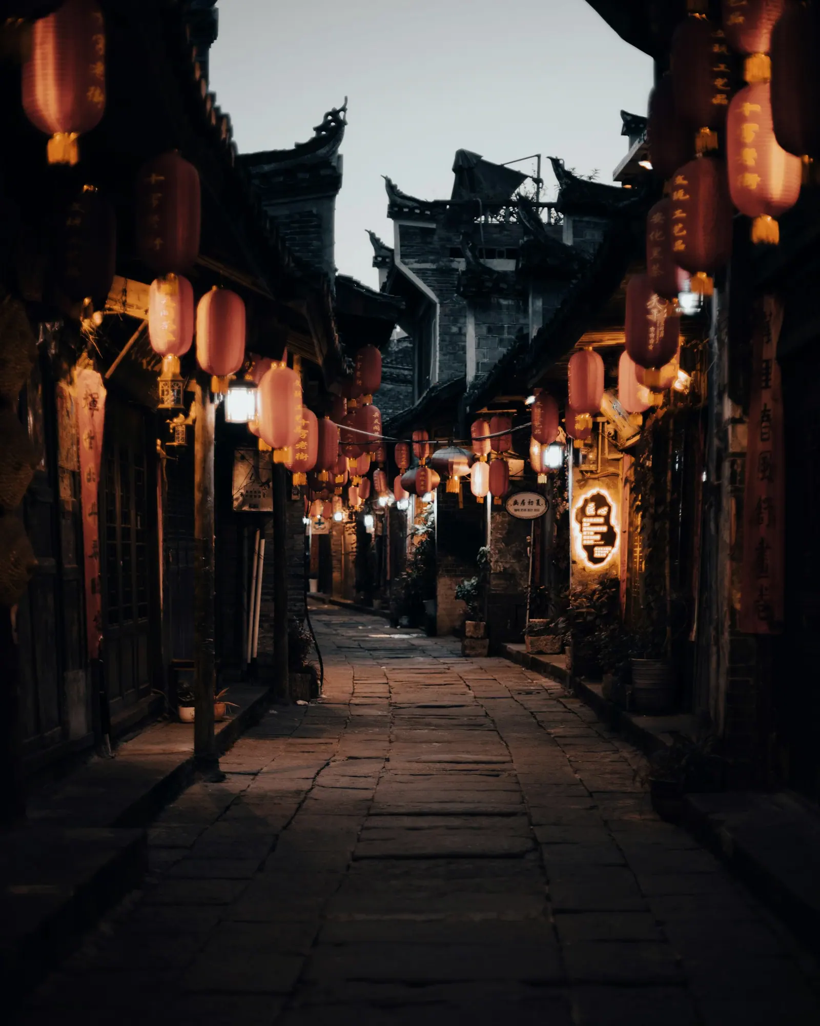 一条挂满红灯笼的老街，路上有零星的行人