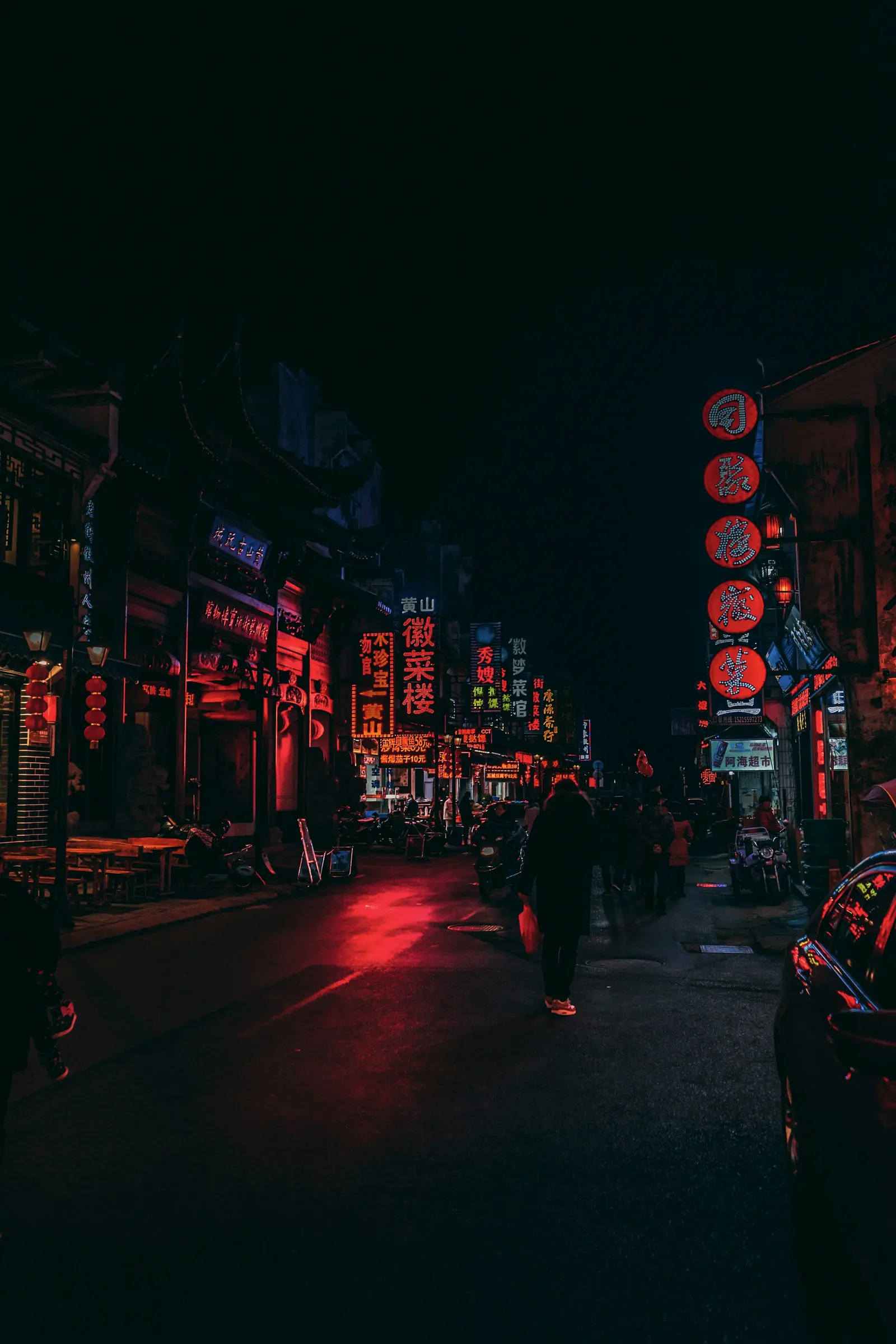 路边站着一个人,背后是几盏红灯笼