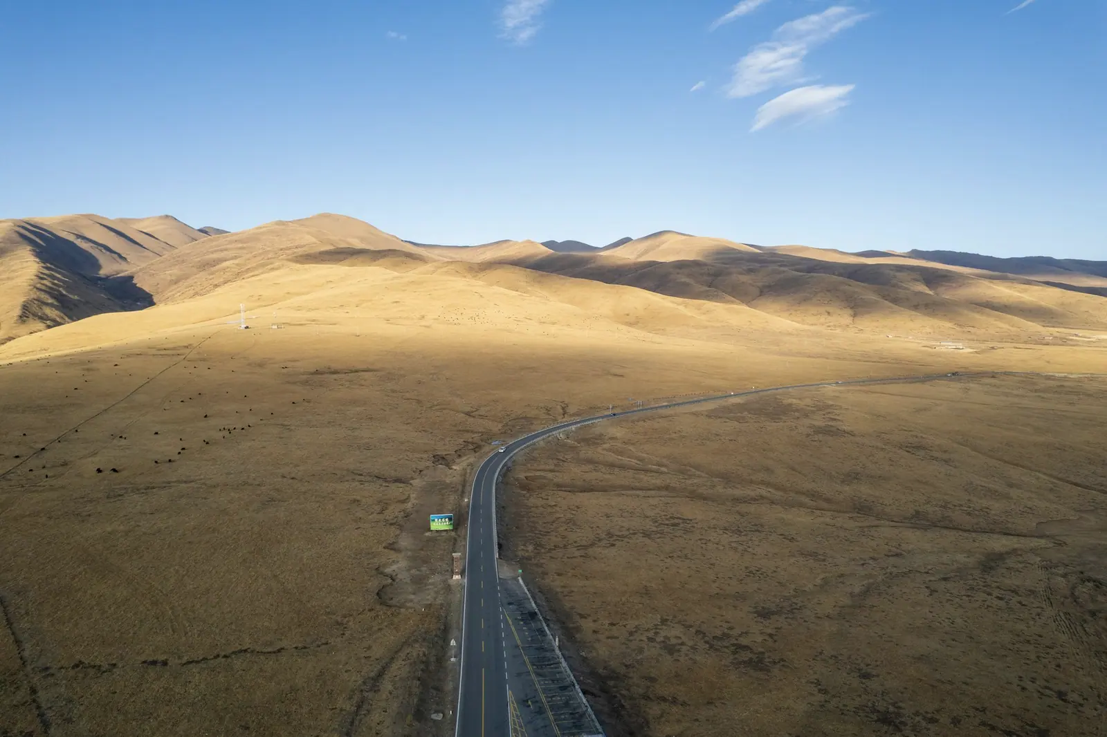 一条笔直的公路伸向金黄色的草山